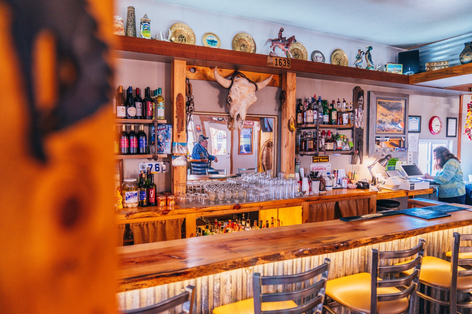 The bar at The Emporium, bottles lined up beneath the steer skull