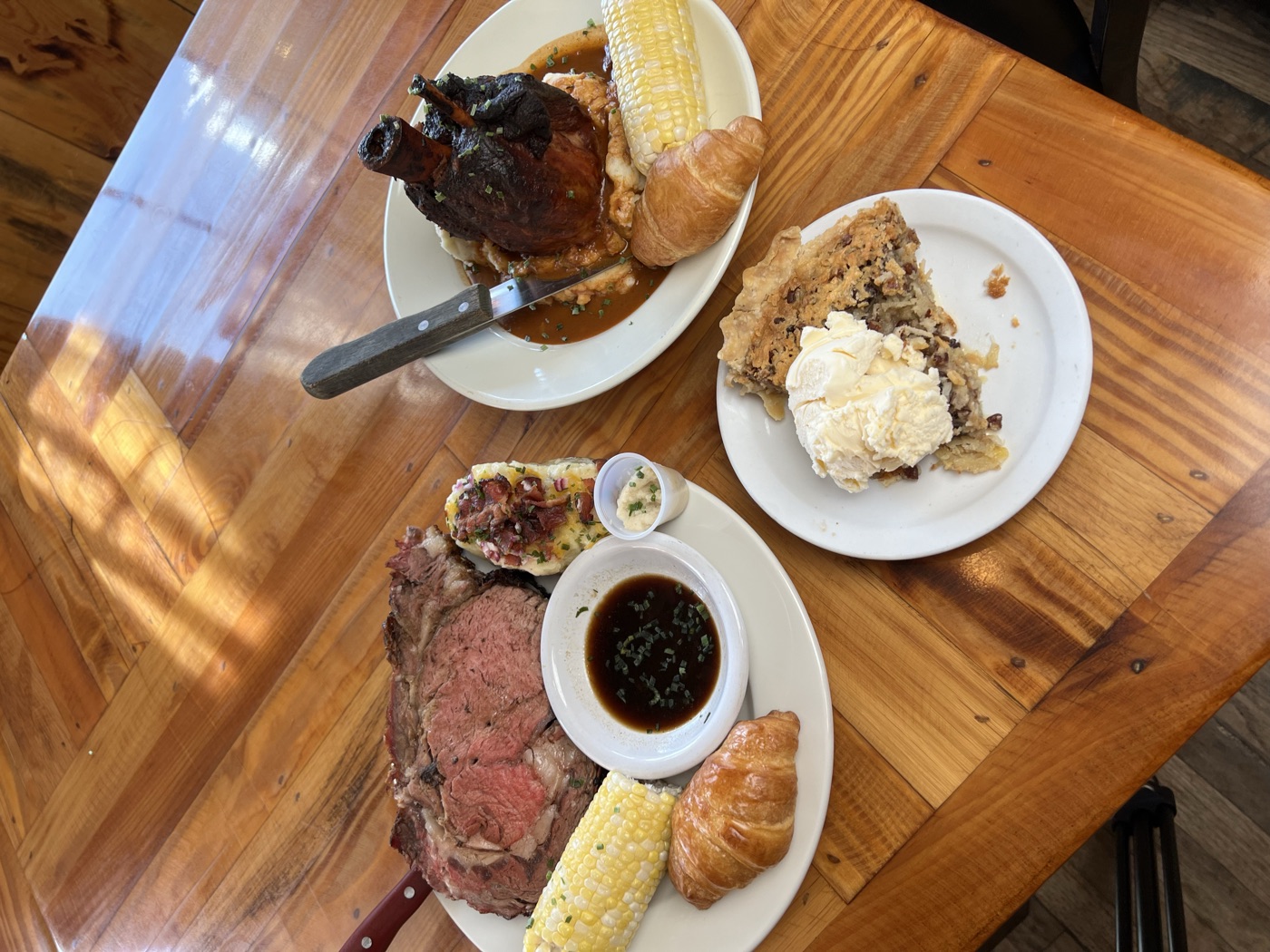 Smoked prime rib plated with au jus and a baked potato
