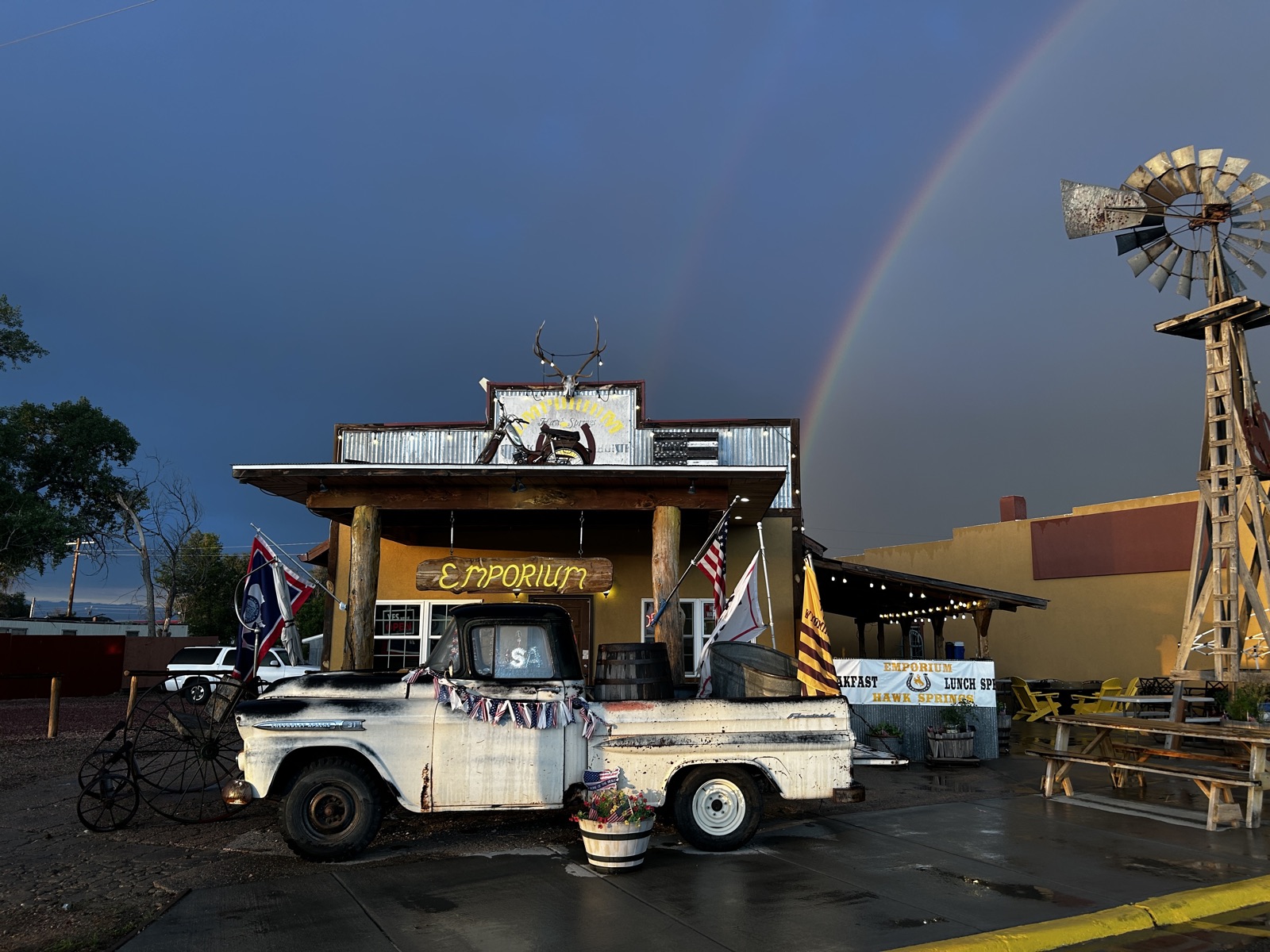 The Emporium on US Highway 85 in Hawk Springs, Wyoming, with a rainbow behind the building and the old pickup out front