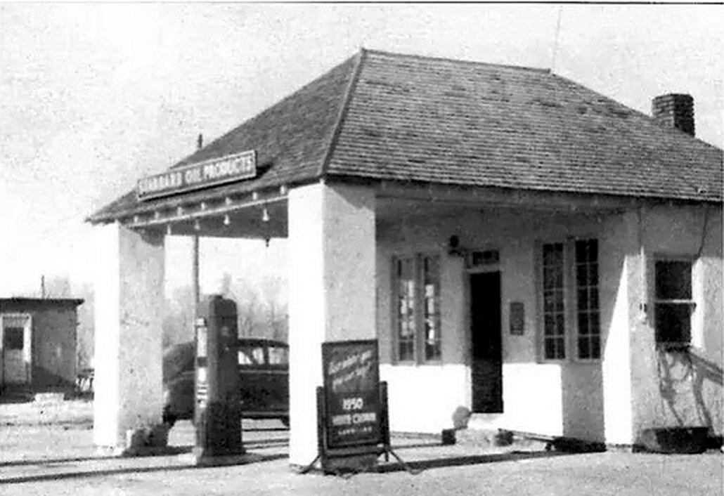 Archive photograph of the Hawk Springs Standard filling station: a hipped-roof building with a covered pump island, a single gas pump and a Standard Oil Products sign