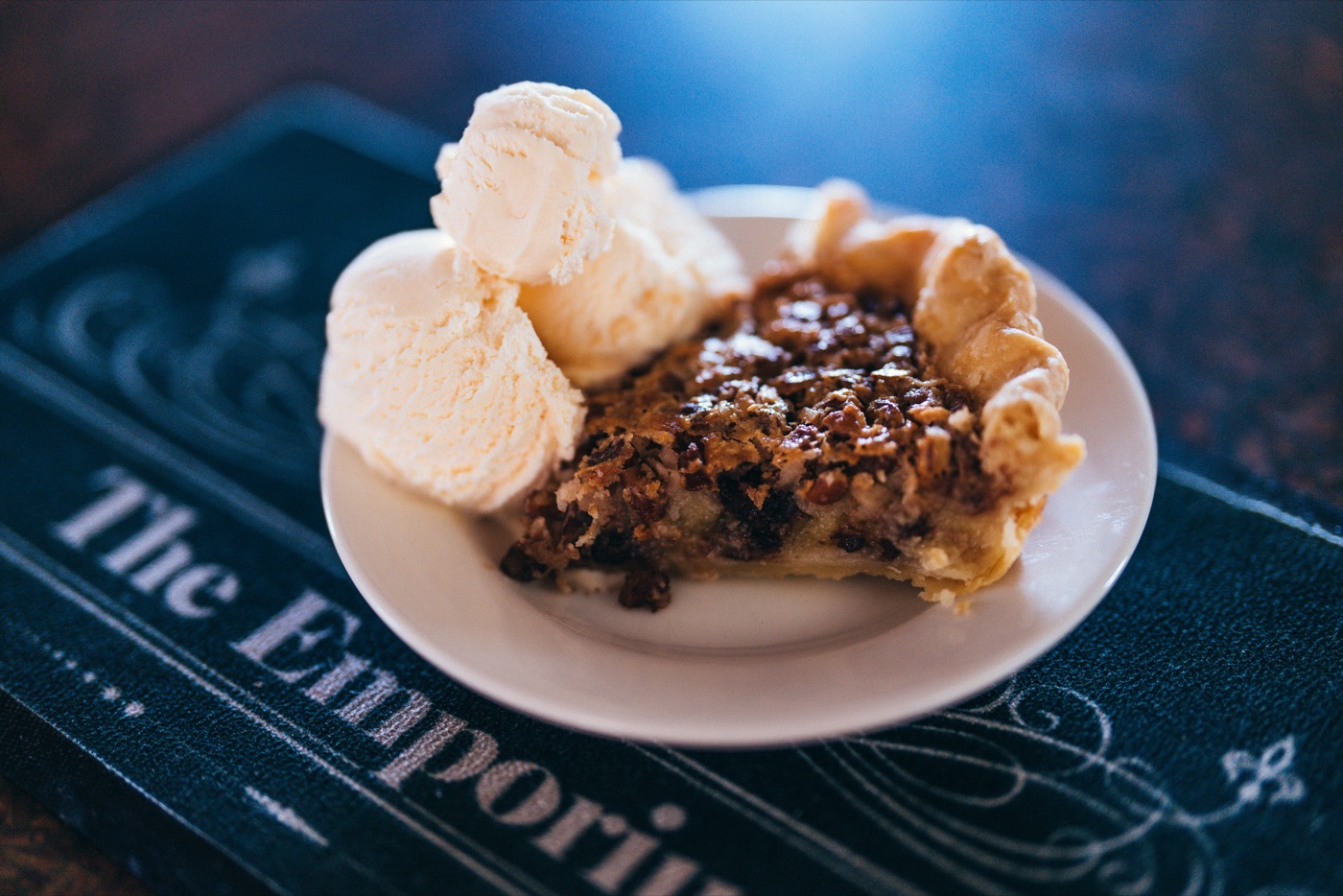 A slice of homemade buttermilk pie with coconut and pecans